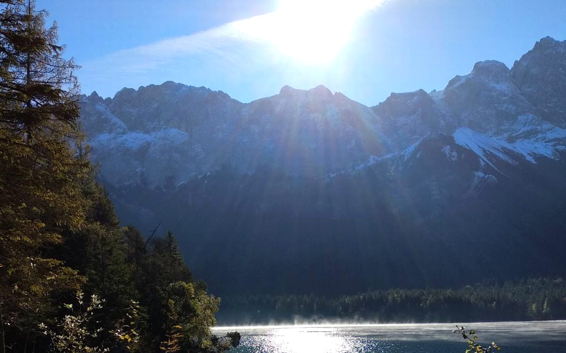 Gegenlicht über dem Eibsee — Sonne über den Bergen, Spiegelung im See